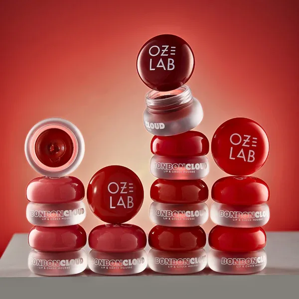Stacked BonBon Cloud lip and cheek mousse jars on red