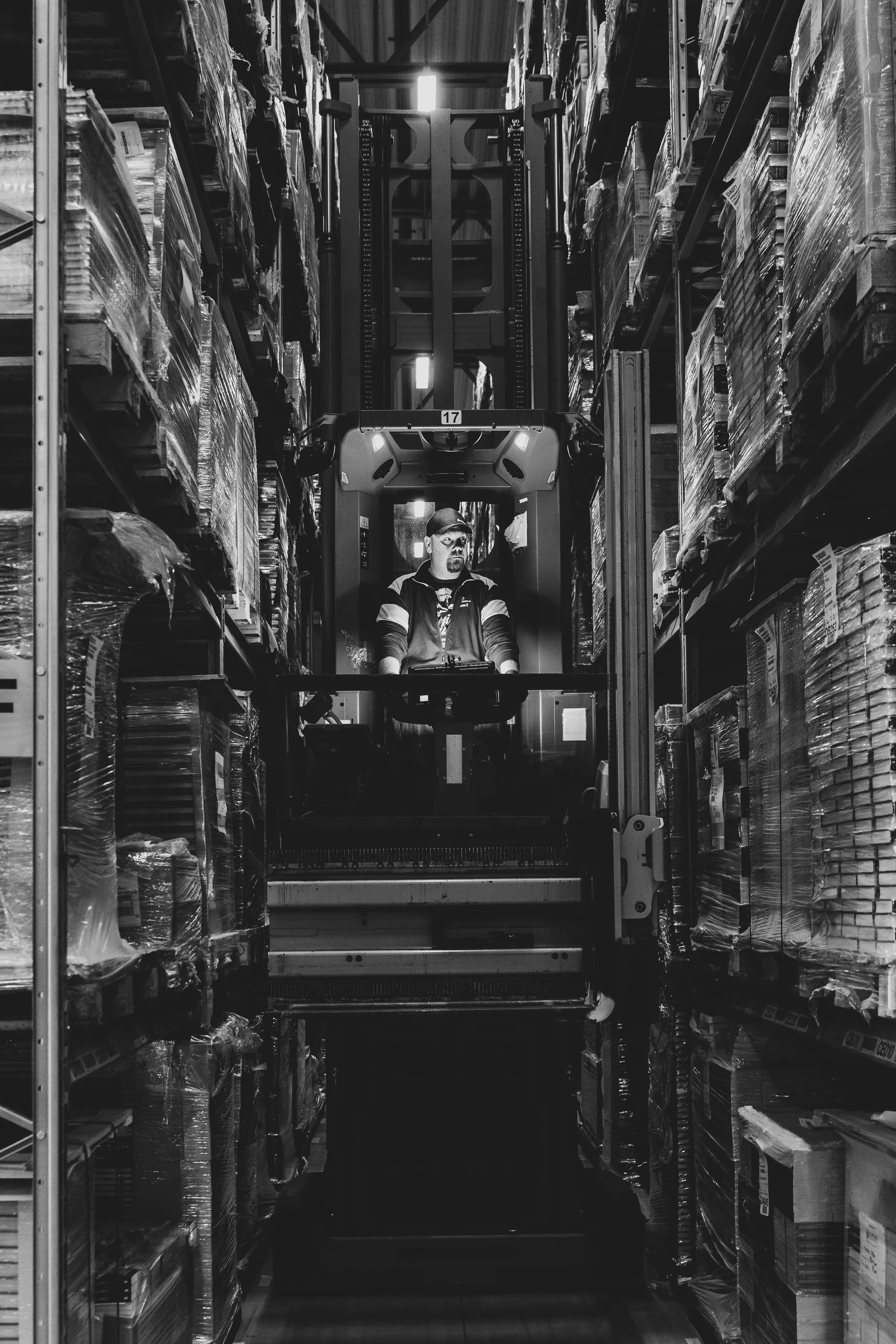 Reach truck working a narrow aisle between high racks